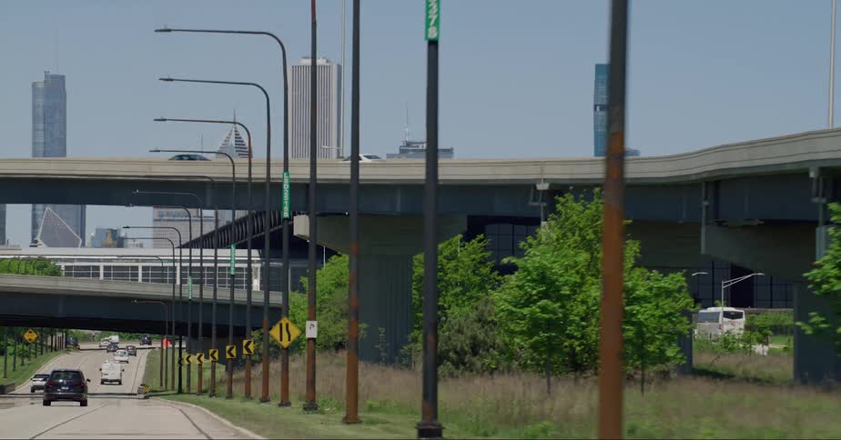 Cars driving on streets with a city skyline in the distance