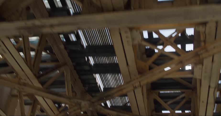 The underside of a traffic bridge is shown as the camera reveals more and more