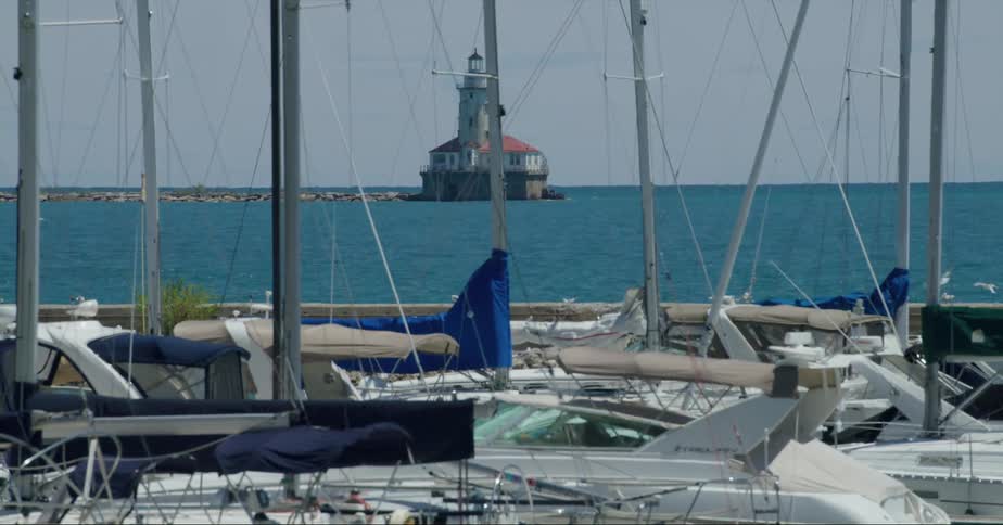 Harbor on the coast with sailboats and lighthouse