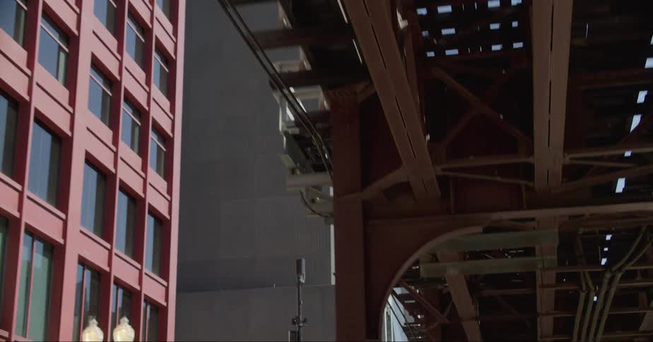 The underside of a bridge next to an office building