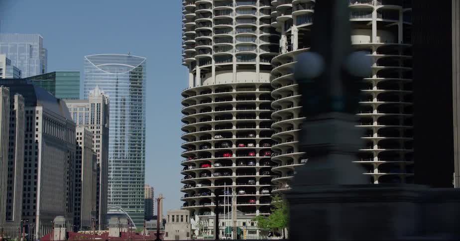 Multistorey car park and high rise buildings seen from vehicle crossing bridge in the city