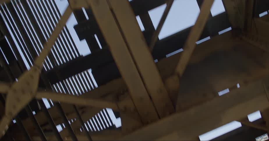 City skyscrapers and sky visible through elevated train track beams