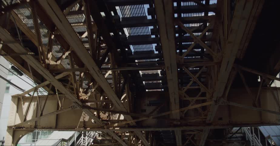 Footage of the underside of the elevated metro tracks on the streets of chicago at daytime