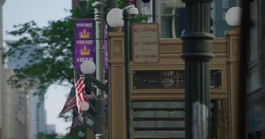 People walk past the entrance to a subway station under downtown
