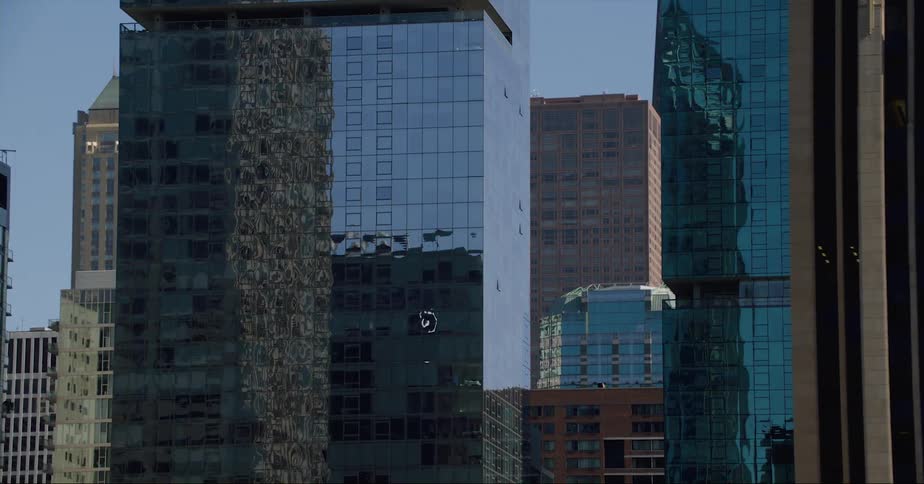 Mirrored skyscrapers reflect off each other in the city skyline