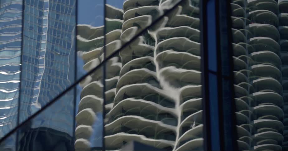 The mirror surface of a downtown building reflects the images of surrounding buildings