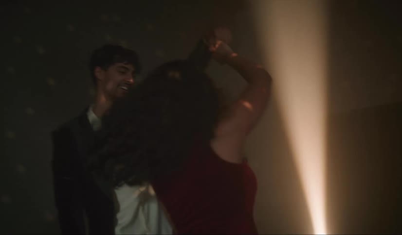 A man twirls a woman as they dance together