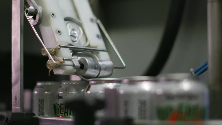 The soda is being fed onto the conveyor belt