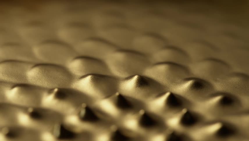 Abstract footage of shapes emerging from a bronze substance