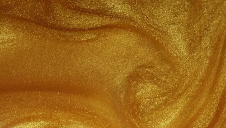 A liquid gold substance sparkles as it swirls and moves