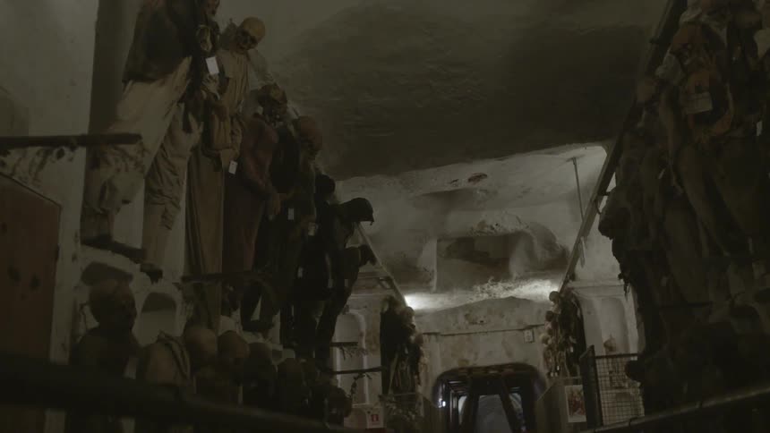 A crypt has many skeletons lining the walls