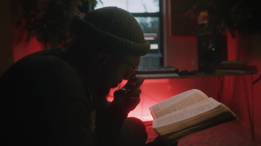A man sits at home and reads a book
