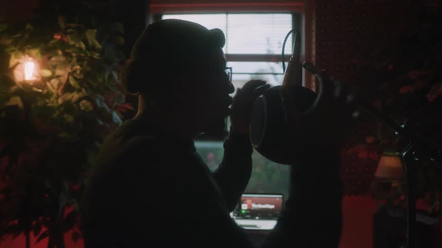 A man sings in to a large microphone