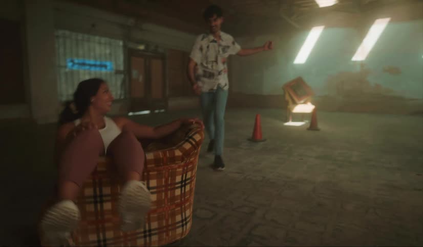Young couple playing with furniture inside an empty abandoned warehouse