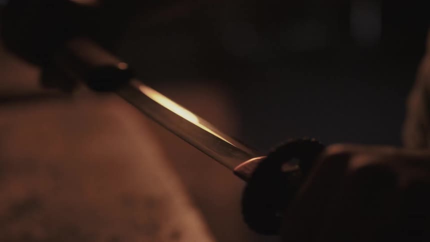 Person removing sword from its sheath