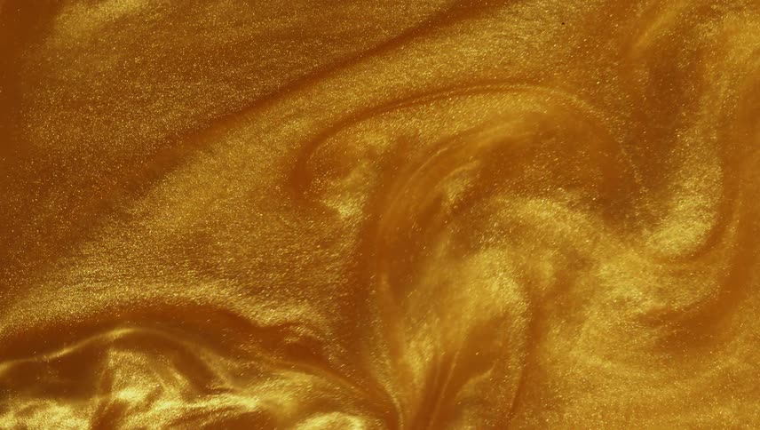 Golden grains flowing and swirling on a liquid surface