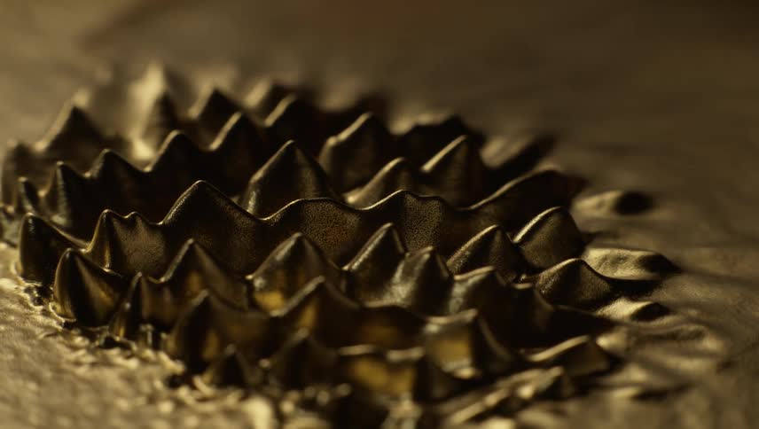 Thorny spikes emerge from a gold liquid substance and move back and forth