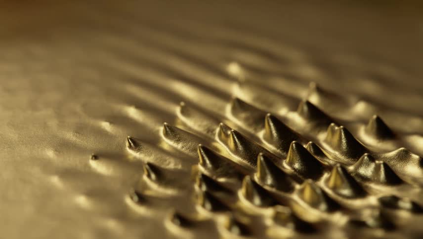 A shiny liquid gold substance moves and spikes emerge and they bend and go back down