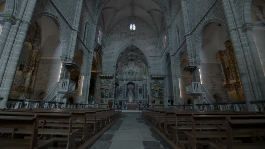 Pews line this church with a arched ceiling