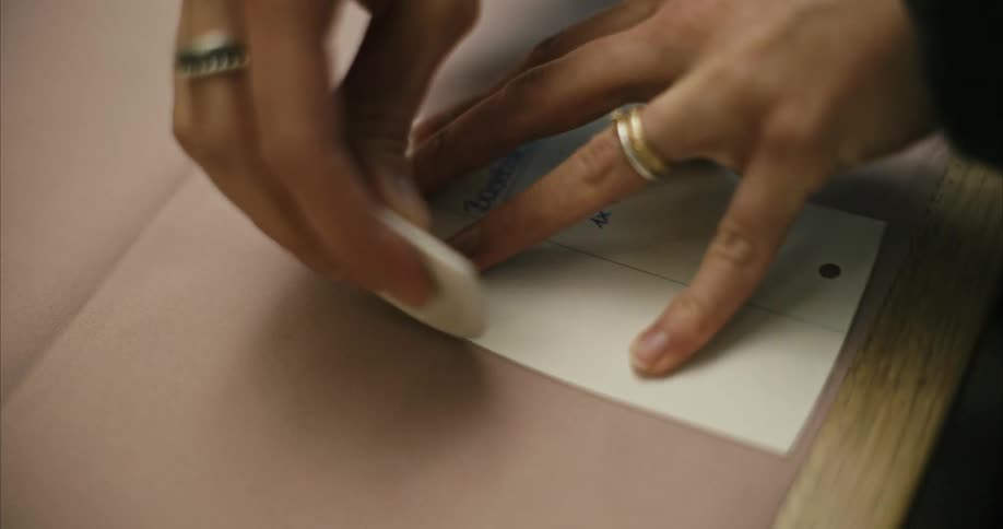 A woman traces the outline of a triangular sheet of paper