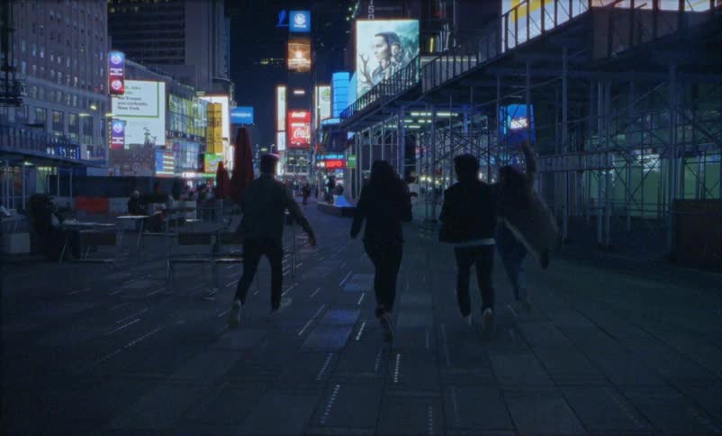 Four women run down the sidewalk in the city