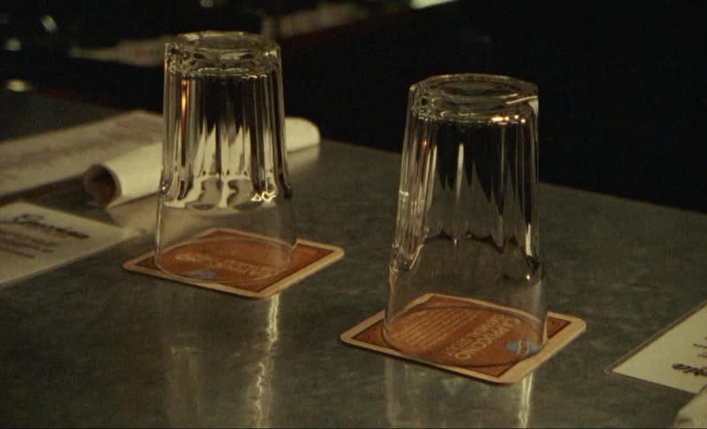Glasses sitting upside down on coasters on a table in a restaurant