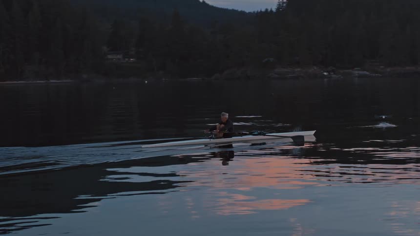 A man paddles a kayak through a lake