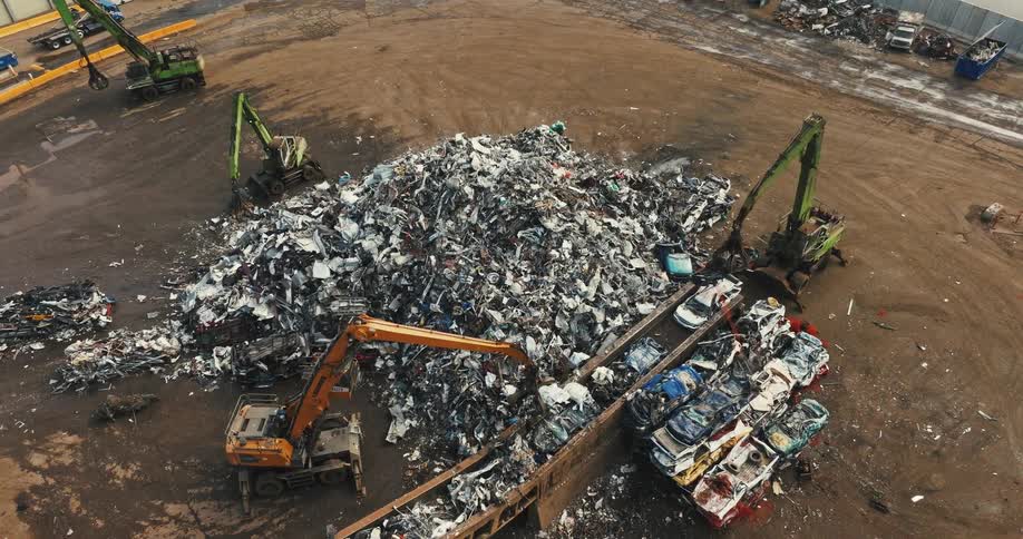 Workers use bulldozers to separate trash at a landfill