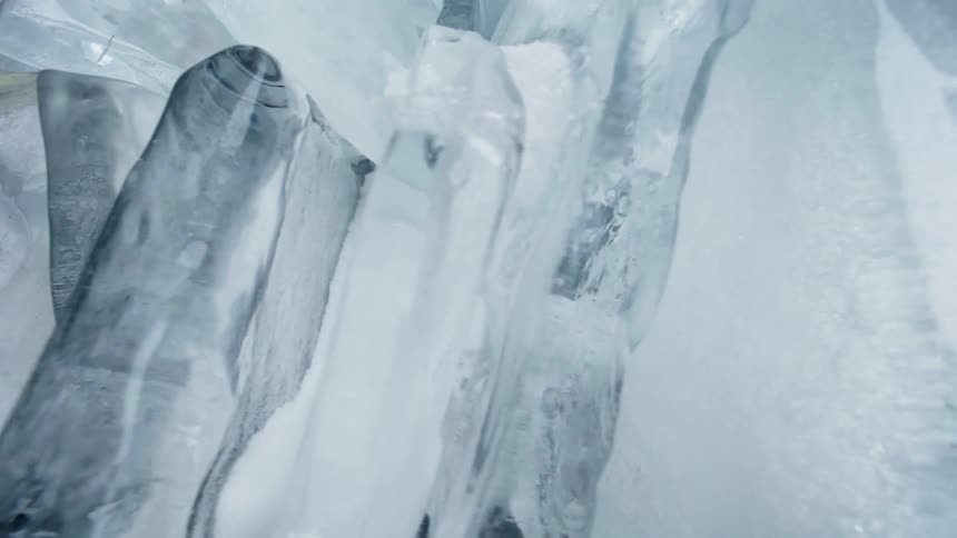 Clear slabs of ice between frosted pieces on a lake