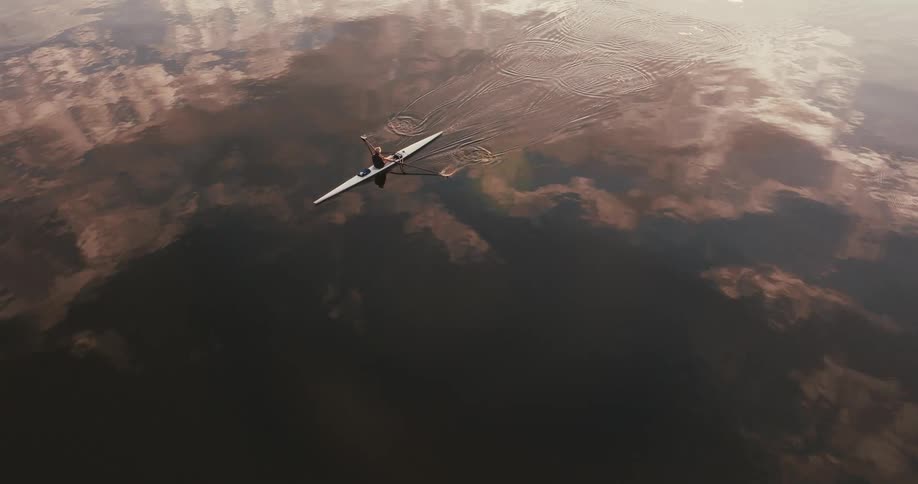 A person is rowing in a kayak in the lake