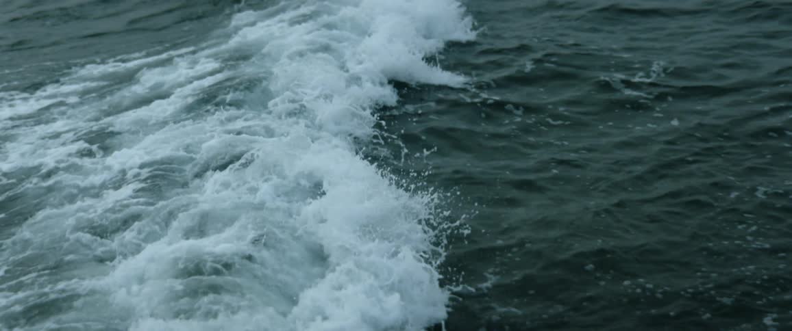 Waves splash and foam as they roll into shore and hit the rocks