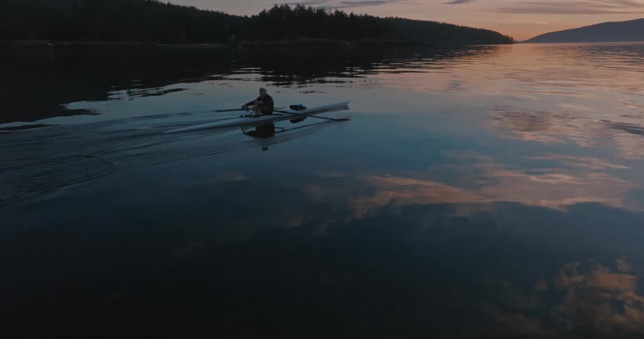 A man rows his canoe further out in a lake