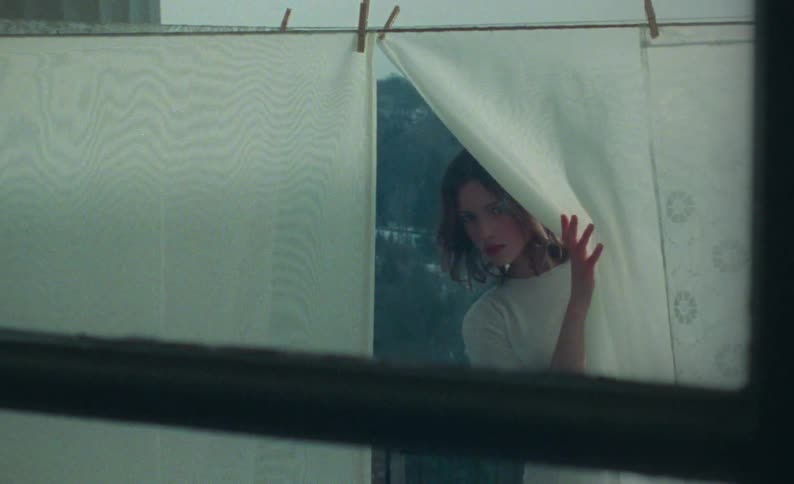 A woman hangs sheets outside to dry