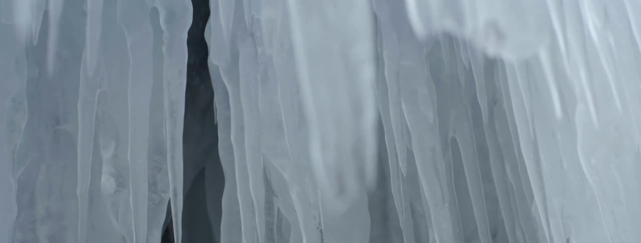 Light shines on huge icicles hanging from above