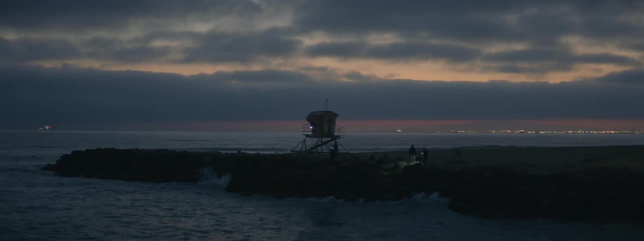 A view of waves on a beach at dusk