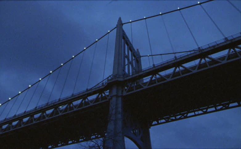 A suspension bridge with lights on in the evening