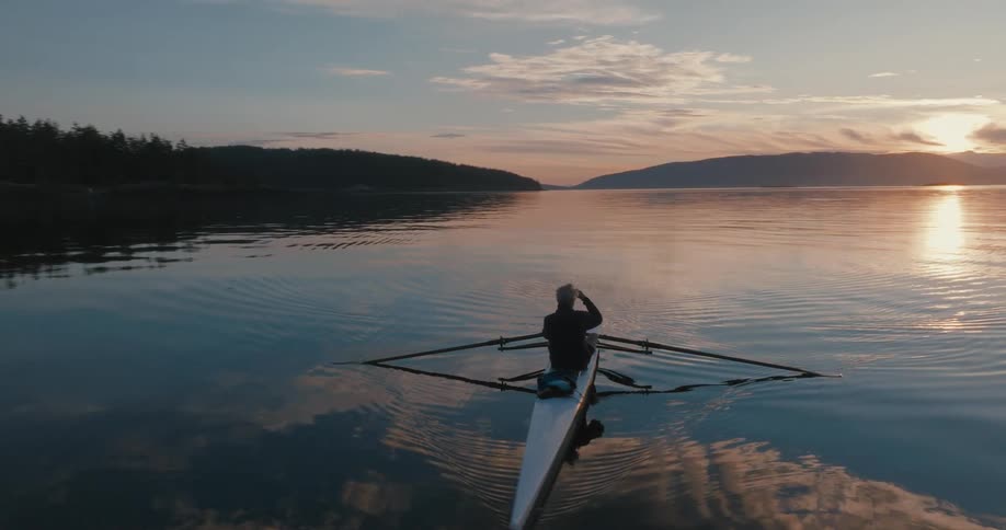 A man watches the sunrise from his kayak