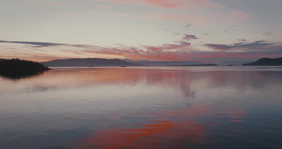 The sun is rising on the lake