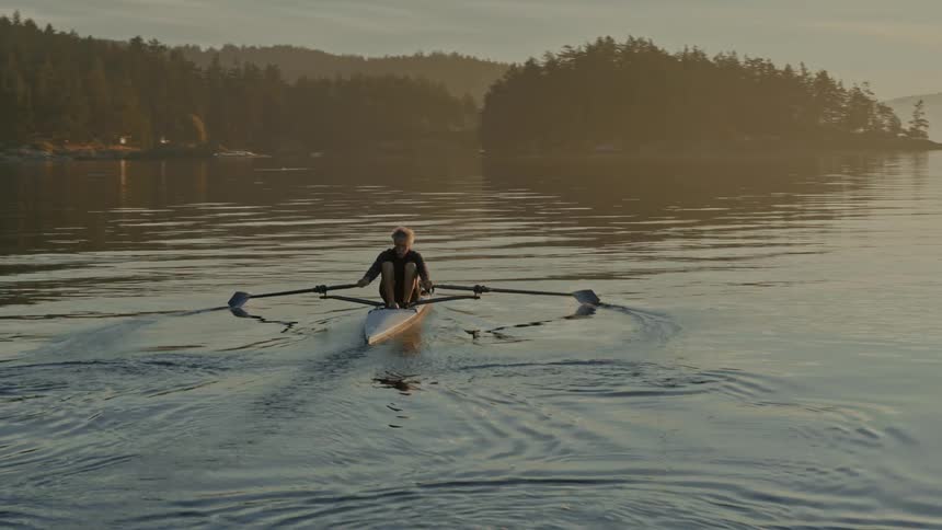 A man kayaks across a lake
