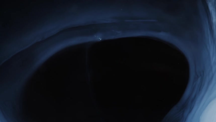 An opaque white liquid spreads out on glass