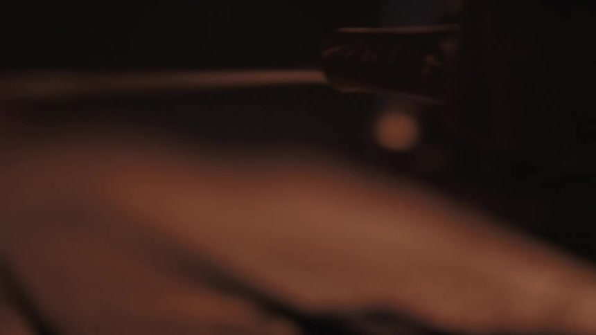 A hand picks up a sword from a table
