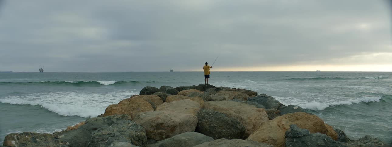 A person is fishing on the shore