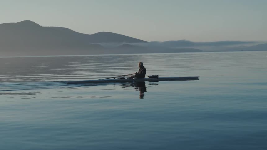 A man is rowing in the large lake