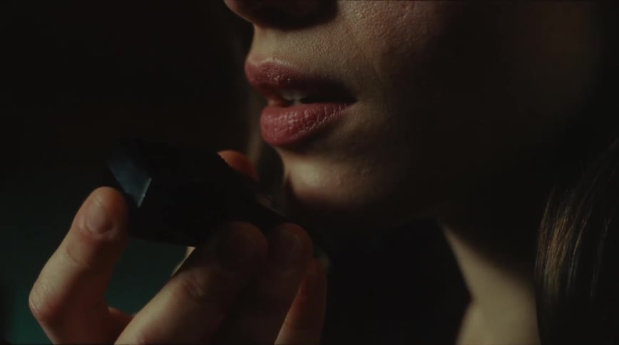 A closeup of a young woman holding a microphone speaker and talking into it