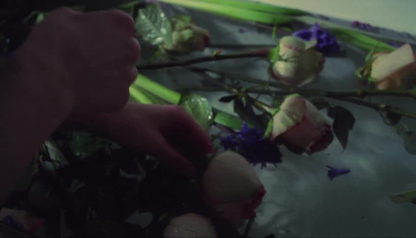 A woman takes a flower from the tub of water
