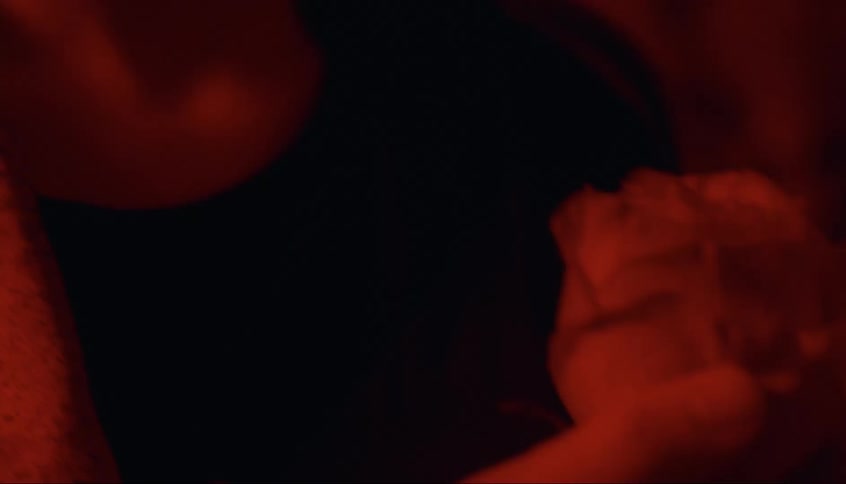 A woman is holding a flower in he dark