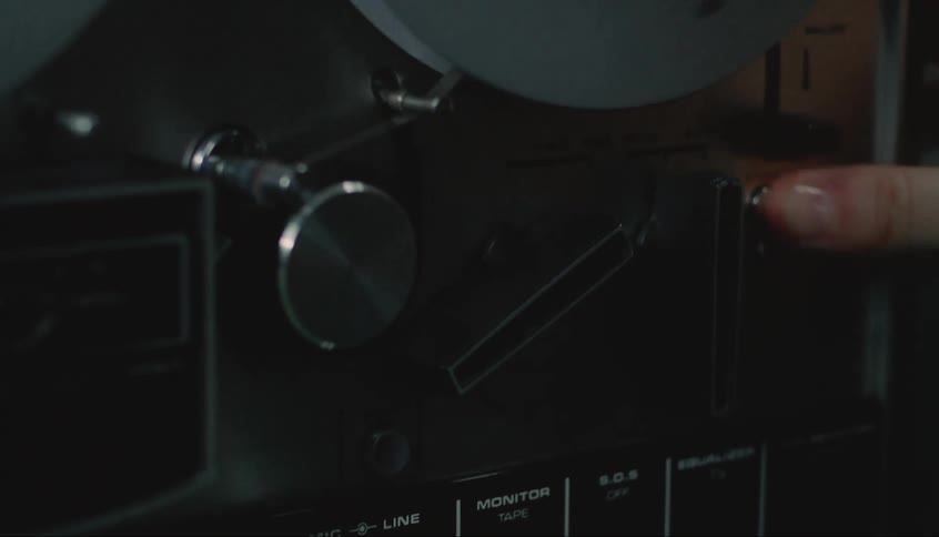 A man turns knobs on a vintage film projector