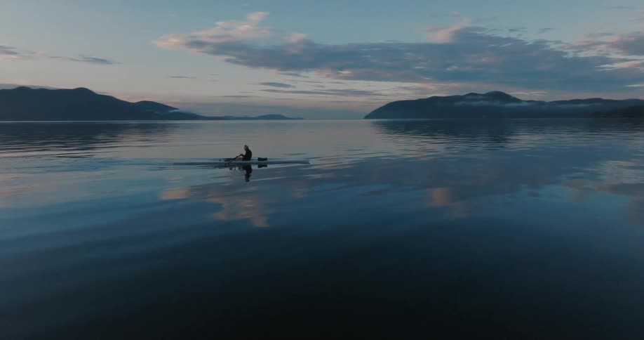 A man paddles a canoe in the ocean