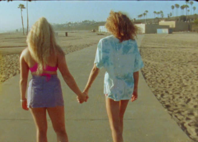 Two women skate on the beach