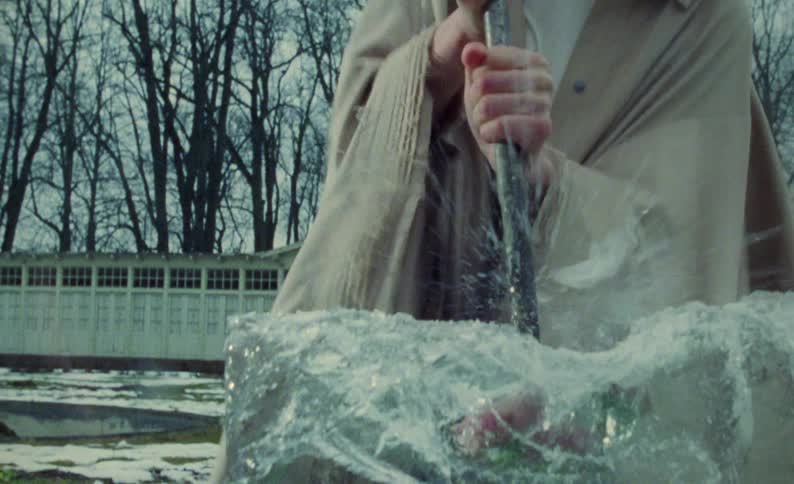 A woman is chopping a block of ice